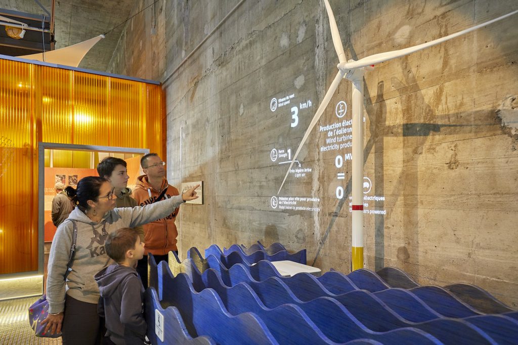 Famille pointant du doigt une éolienne dans EOL, centre d'interprétation consacré à l'éolien en mer.