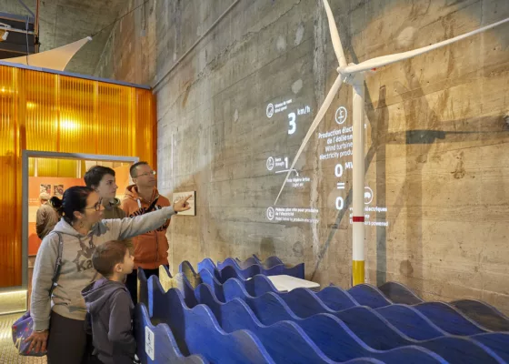 Famille pointant du doigt une éolienne dans EOL, centre d'interprétation consacré à l'éolien en mer.