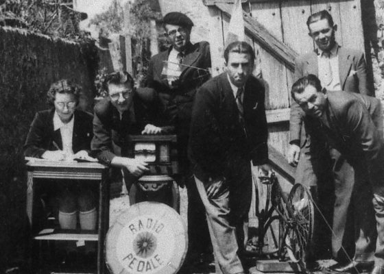 Photographie de civils de la Poche de Saint-Nazaire posant devant leur invention, le radio-pédale.