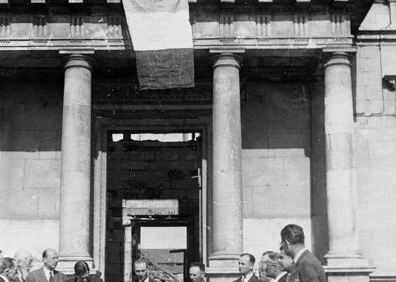 Photographie du conseil municipal de Saint-Nazaire se réunit le 9 juin 1945 devant l'ancien hôtel de ville en ruines.