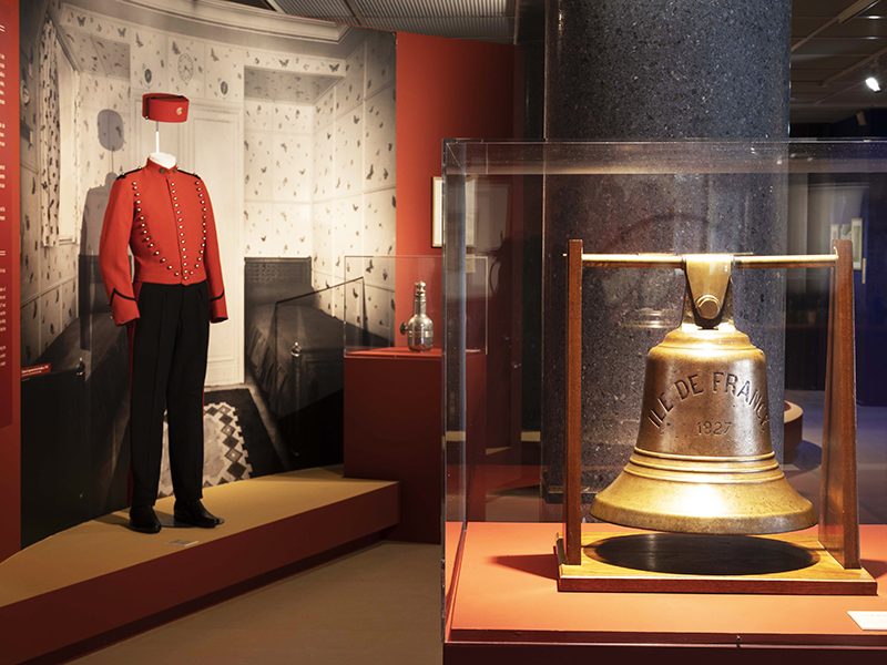 Vue d'une cloche et d'un costume de groom dans l'exposition "L’Art déco, un art de vivre : le paquebot Ile-de-France" au musée des Années 30 de Boulogne-Billancourt.