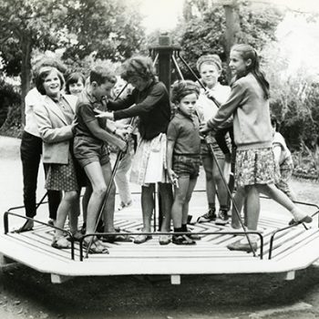 Des enfants jouent sur un tourniquet dans un parc en juillet 1963.