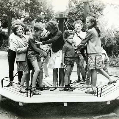 Détail. Photographe inconnu. Collection Saint-Nazaire Agglomération Tourisme - Écomusée. Fonds Ouest-France Des enfants jouent sur un tourniquet dans un parc en juillet 1963.