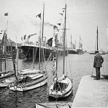 À droite de l'image, un homme regarde des paquebots dans le bassin de Saint-Nazaire.