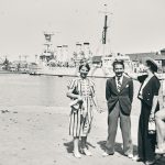 Quatre femmes et un homme posant devant le bassin du port de Saint-Nazaire et un navire militaire.