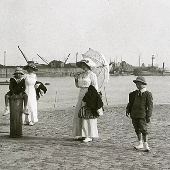 Deux femmes en robes blanches du début du siècle posent avec deux enfants au niveau de l'avant-port de Saint-Nazaire.