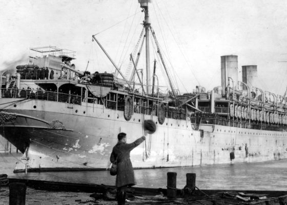 Sous-lieutenant américain agitant son couvre-chef en guise d’au-revoir sur un quai de Saint-Nazaire à la fin de la guerre.