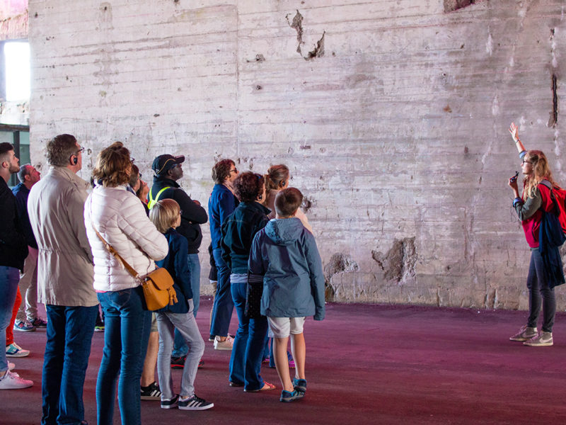 Guide s'adressant à un groupe lors d'une visite de la base sous-marine pendant les Journées du patrimoine, événement de la Saison patrimoine.