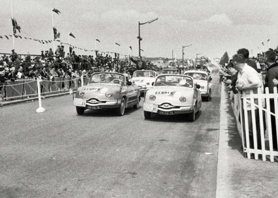 Voitures Panhard paradant devant la foule lors du passage du Tour de France cycliste en 1958.