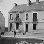 Jeu "Où est-ce à Saint-Nazaire ?" Famille posant devant sa maison fraîchement construite dans une rue en travaux au début du 20e siècle.