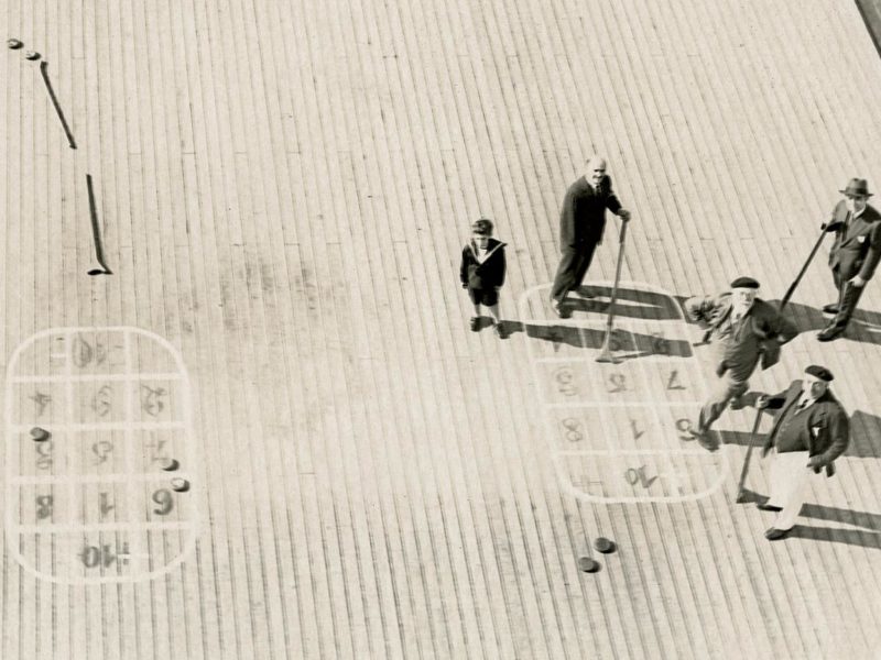 Vue aérienne d'un pont de paquebot avec des passagers jouant au shuffleboard.