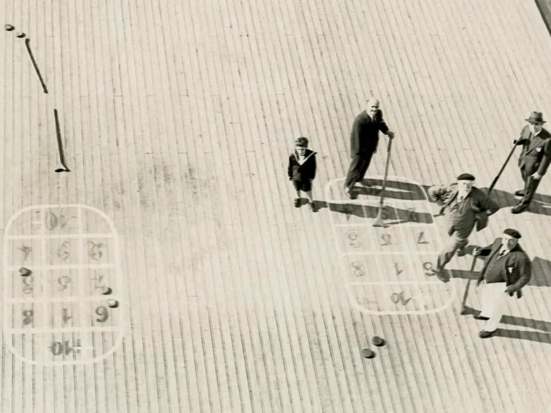 Détail. Photographe inconnu. Collection Saint-Nazaire Agglomération Tourisme-Écomusée Vue aérienne d'un pont de paquebot avec des passagers jouant au shuffleboard.