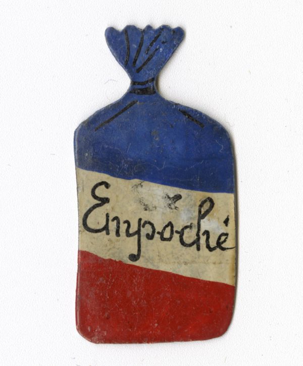 Insigne en forme de petit sac arborant les couleurs du drapeau français, au centre le mot "empoché" en référence à la Poche de Saint-Nazaire.