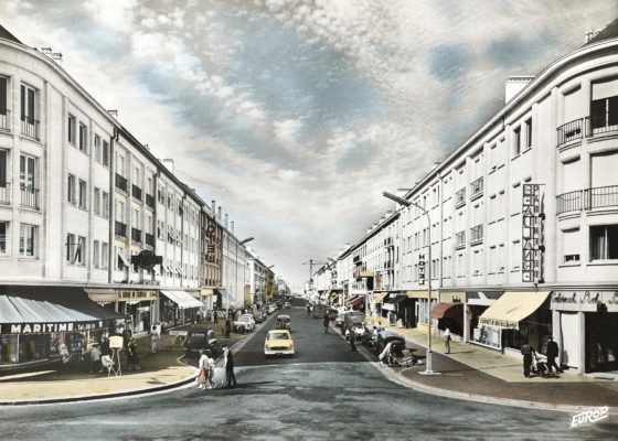 Carte postale colorisée montrant la perspective de l'avenue de la République avec les immeubles la bordant de chaque côté.