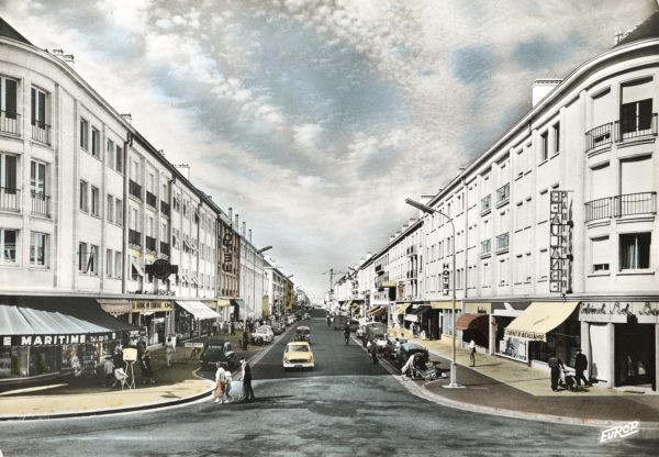 Carte postale colorisée montrant la perspective de l'avenue de la République avec les immeubles la bordant de chaque côté.