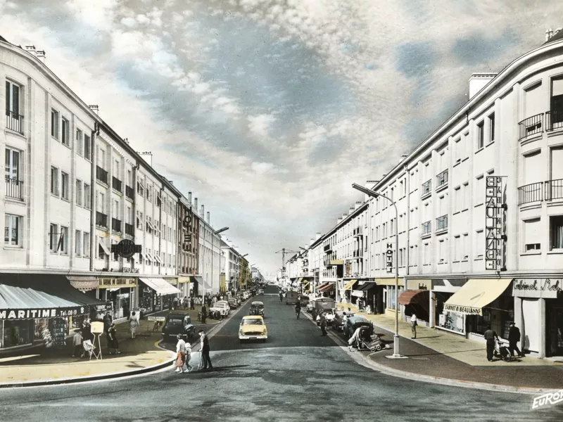 Photographe inconnu. Éditeur : Europ. Collection Saint-Nazaire Agglomération Tourisme-Écomusée Carte postale colorisée montrant la perspective de l'avenue de la République avec les immeubles la bordant de chaque côté.
