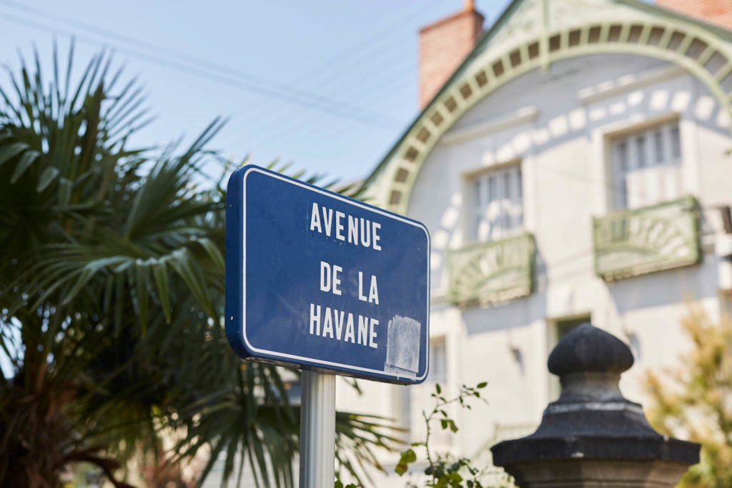 Panneau de rue indiquant l'avenue de la Havane devant la façade d'une maison bourgoise.