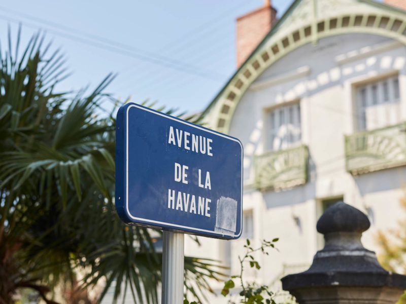 Photographe : Alexandre Lamoureux Panneau de rue indiquant l'avenue de la Havane devant la façade d'une maison bourgoise.
