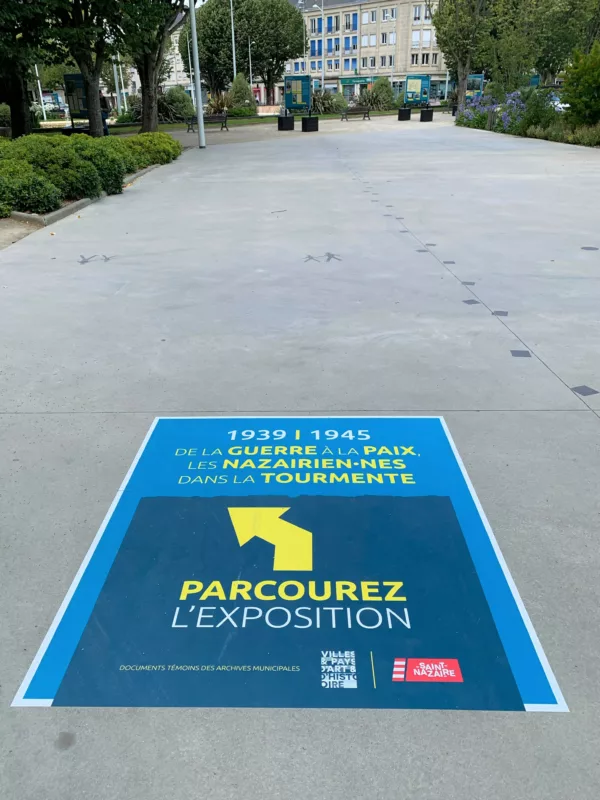 Photographe : Pierre Sabouraud Panneau de l'exposition sur la Seconde Guerre mondiale collé au sol sur l'avenue Léon Blum à Saint-Nazaire.