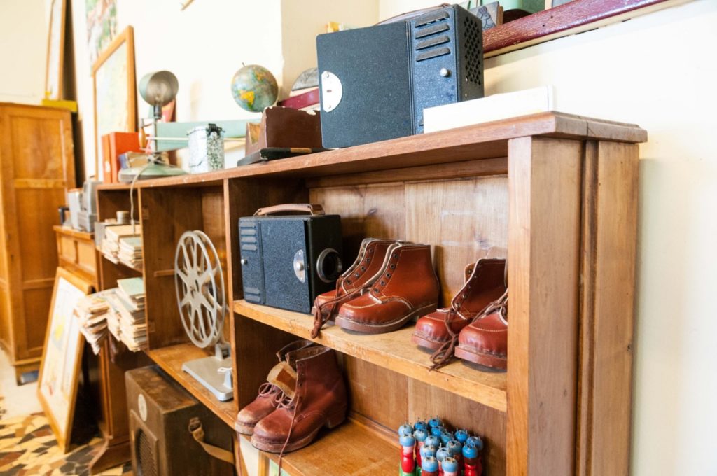 Vue d'une armoire de la classe des années 1950 de l'école Jean Jaurès où se trouve de vieilles chaussures en cuir.