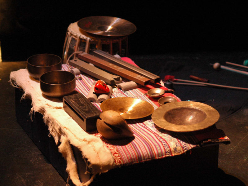 Divers instruments de musique à percussion posés sur une table basse.