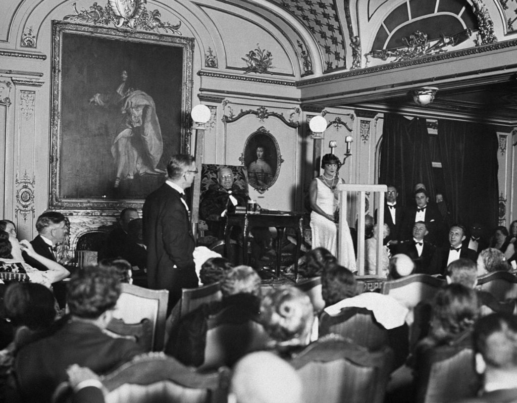 Des passagers assistent à une représentation théâtrale dans le grand salon première classe du paquebot France (1912), le 11 juillet 1931.