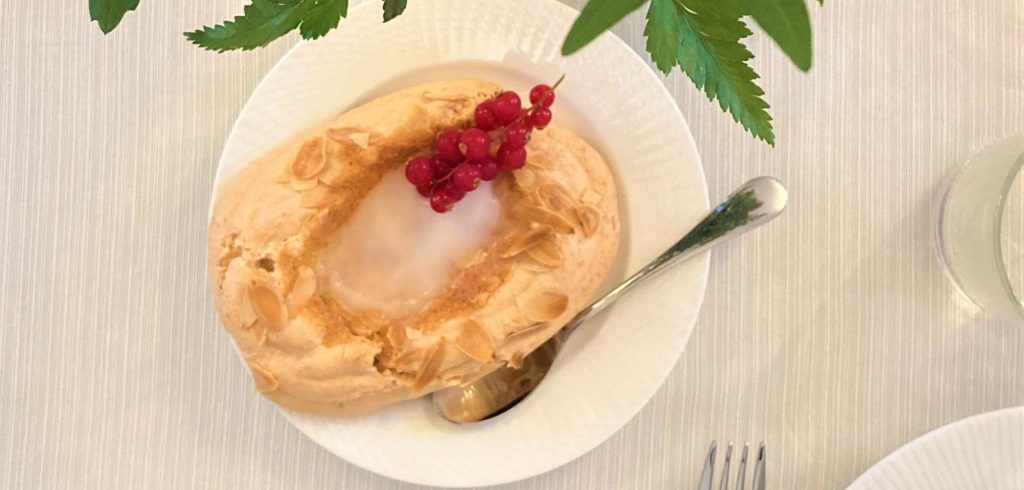 Gâteau aux amandes de forme ovale posé dans une assiette blanche.