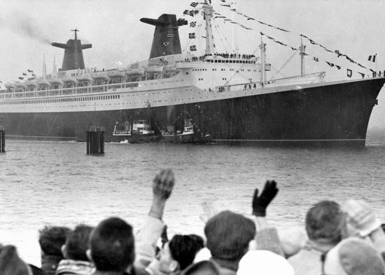 Paquebot France sortant du port de Saint-Nazaire, au premier plan une foule agite les bras.