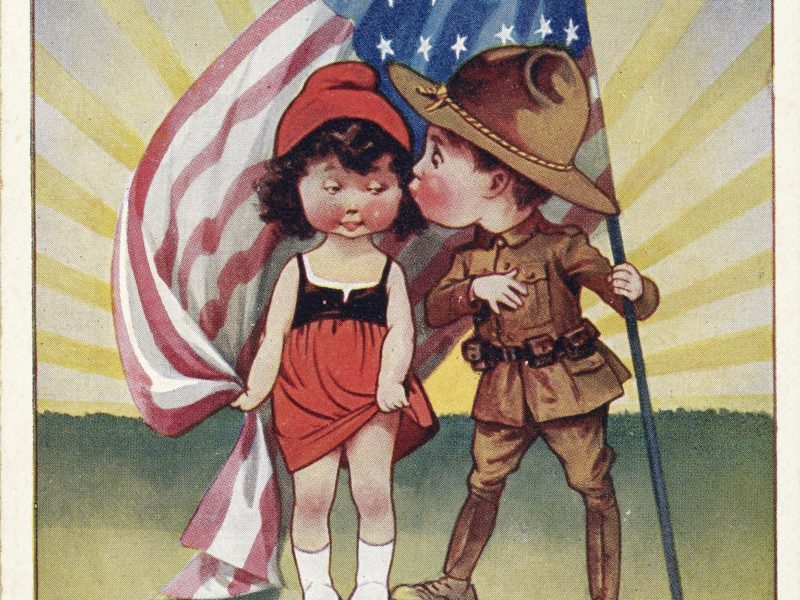 Carte postale avec une illustration dessinée en couleur représentant un petit garçon en uniforme américain et une petite fille en costume alsacien et bonnet phrygien. Le garçon tient un drapeau américain.