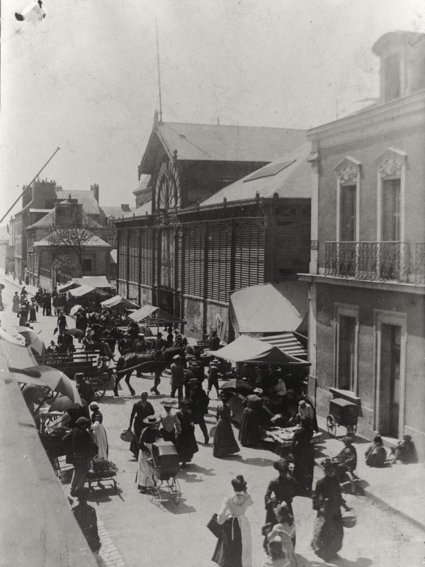 Photographie en noir et blanc d'une foule un jour de marché aux halles de Saint-Nazaire.