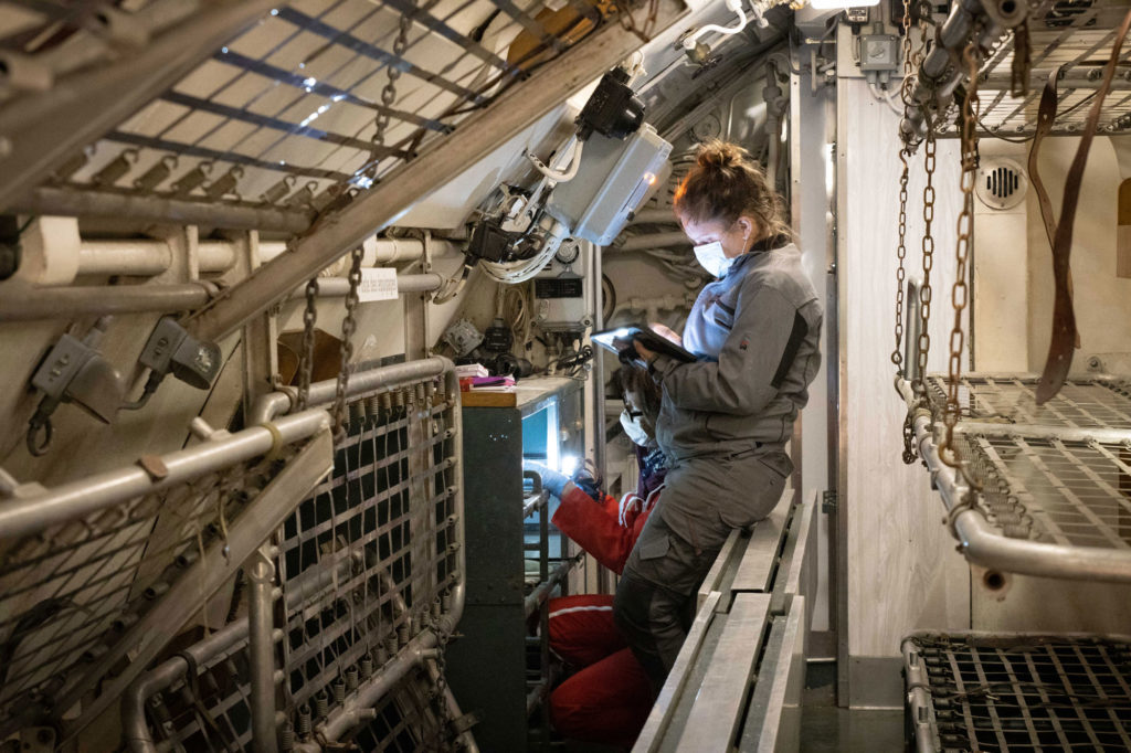 Photographie d'experts-restaurateurs réalisant un constat d’état du sous-marin