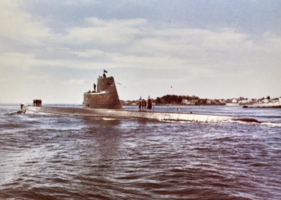 Sous-marin Espadon en mer près des côtes, quelques membres de l'équipage sont debout sur la coque.