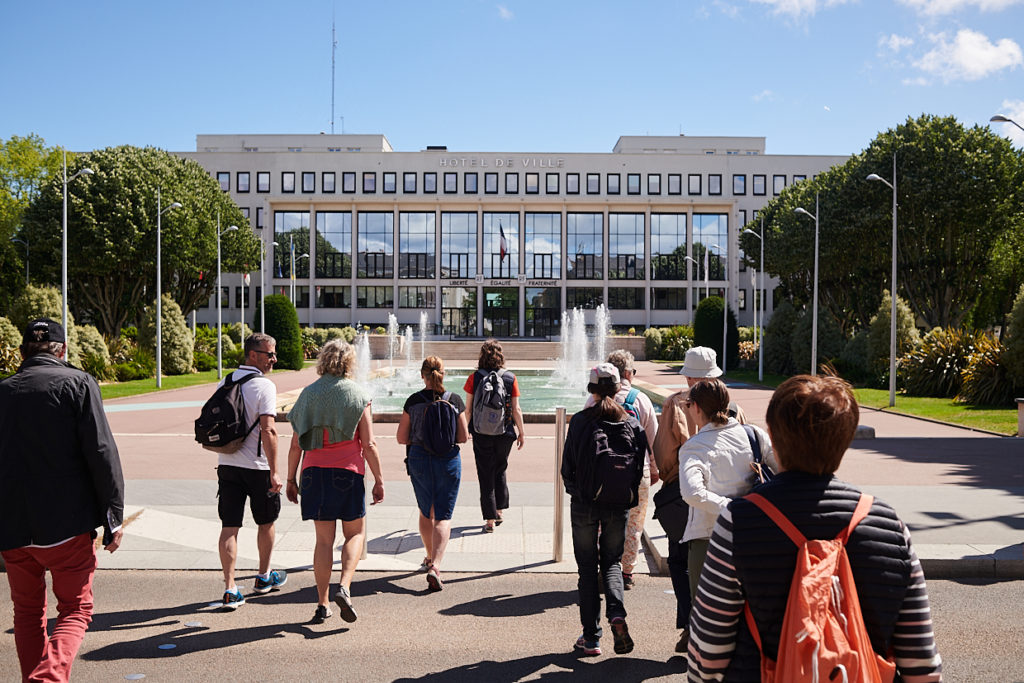 Groupe de visiteurs pendant une visite guidée devant l'hôtel de ville de Saint-Nazaire.