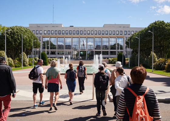 Groupe de visiteurs pendant une visite guidée devant l'hôtel de ville de Saint-Nazaire.
