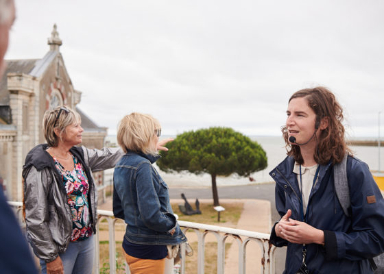 Guide et visiteurs devant l'entrée du port de Saint-Nazaire lors de la visite "La porte du large".