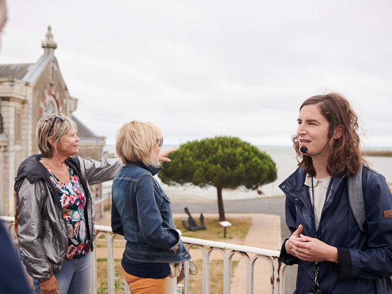 Guide et visiteurs devant l'entrée du port de Saint-Nazaire lors de la visite "La porte du large".