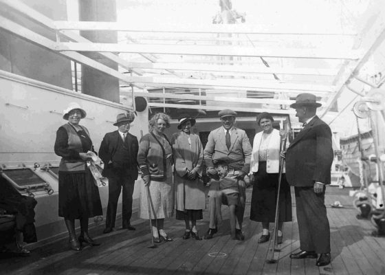 Photographie en noir et blanc illustrant des passagers sur le pont d'un paquebot avec un jeu de shuffle board.