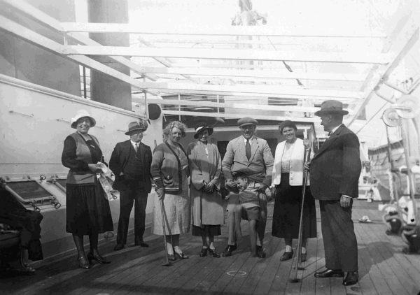 Photographie en noir et blanc illustrant des passagers sur le pont d'un paquebot avec un jeu de shuffle board.