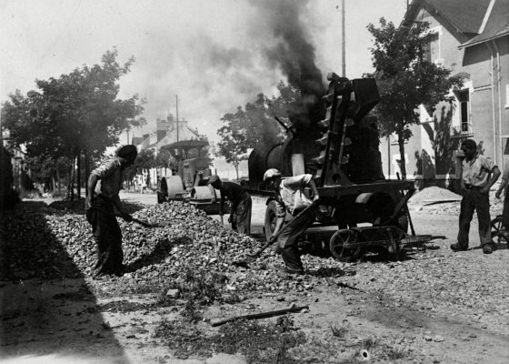 Photographie en noir et blanc d'une réfection de la voirie pendant la reconstruction de Saint-Nazaire.