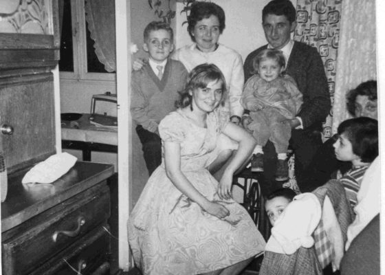 Photographie en noir et blanc sur laquelle pose une famille dans un appartement H.L.M.
