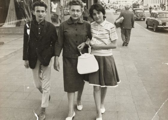 Photographie en noir et blanc représentant une famille se promenant sur l'avenue de la République pendant la reconstruction de Saint-Nazaire.