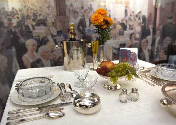 Photographie en gros plan d'une table dressée comme à bord de la salle à manger première classe du paquebot Normandie dans l'exposition "La table, un art français" à l'Hôtel départemental du Var à Draguignan.