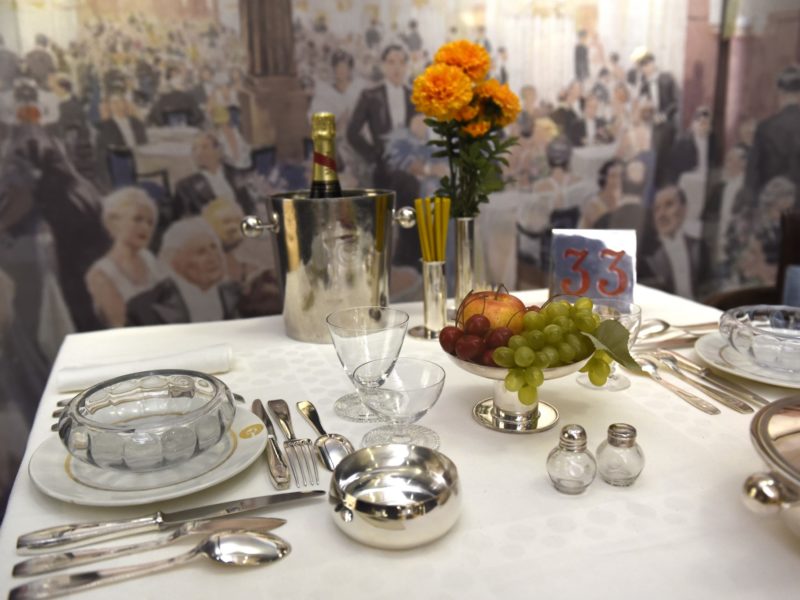 Photographie en gros plan d'une table dressée comme à bord de la salle à manger première classe du paquebot Normandie dans l'exposition "La table, un art français" à l'Hôtel départemental du Var à Draguignan.