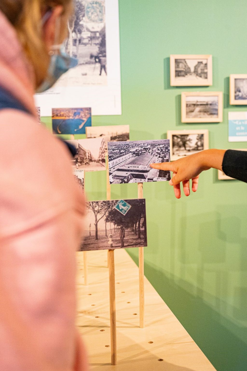 Femme montrant du doigt une carte postale dans l'exposition 
