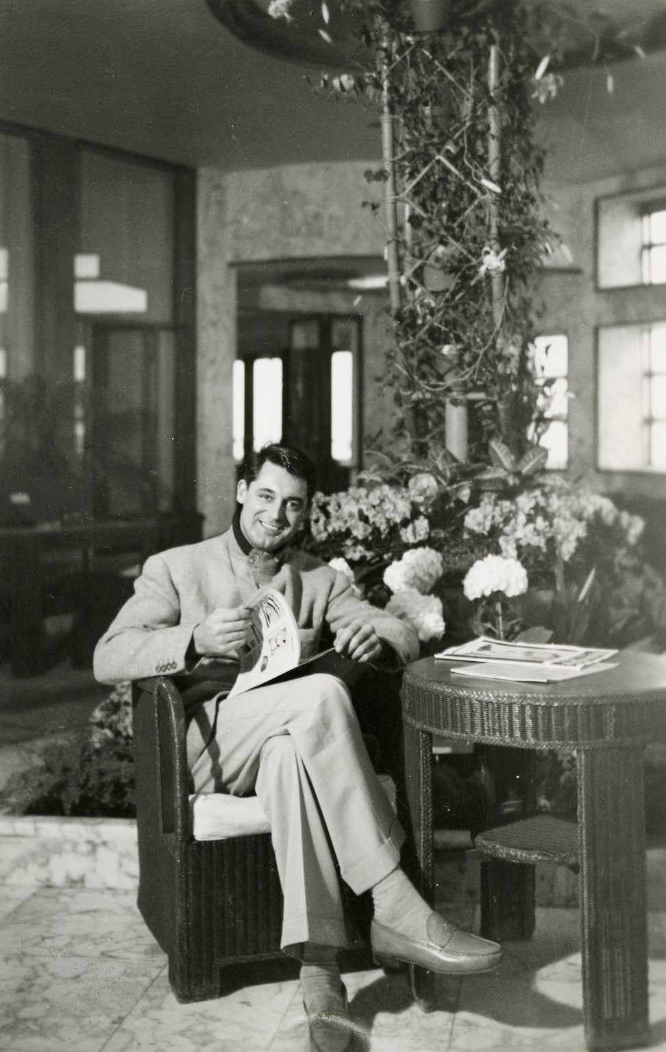 Portrait de l'acteur Cary Grant dans le jardin d'hiver du paquebot Normandie.