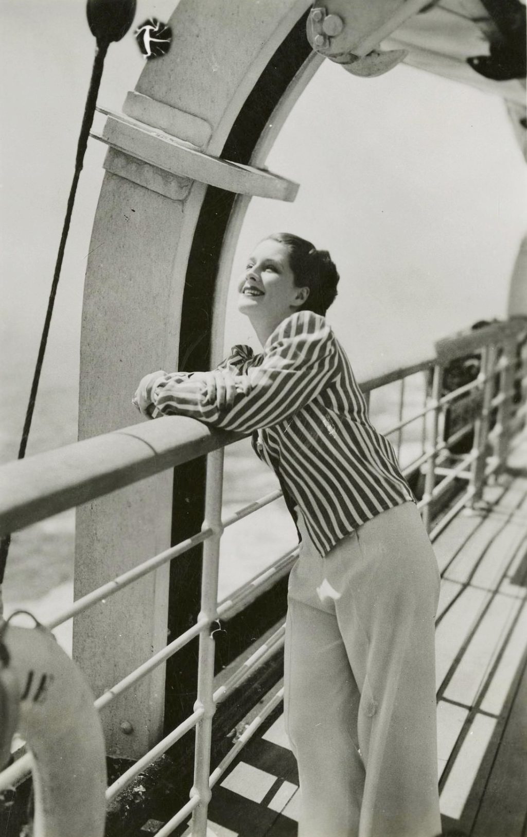 Portrait de l'actrice Norma Shearer accoudée sur le pont du paquebot Normandie.