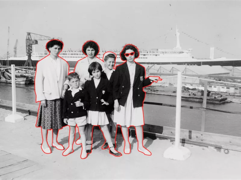 Photographe : inconnu. Collection Saint-Nazaire Agglomération Tourisme - Écomusée. Création graphique : Maelwenn Leduc Photographie en noir et blanc représentant un groupe posant devant le paquebot France le jour de son lancement.