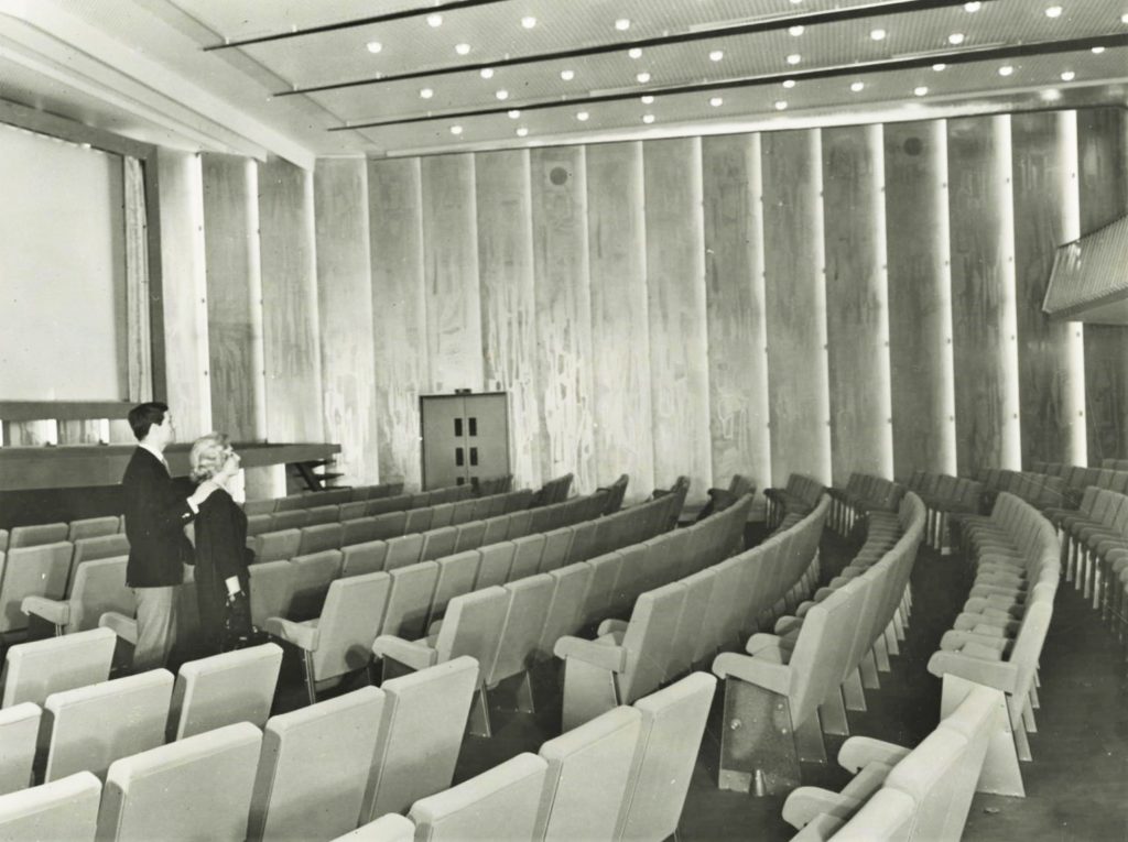 Un couple de passagers regarde le décor du théâtre du paquebot France (1962).