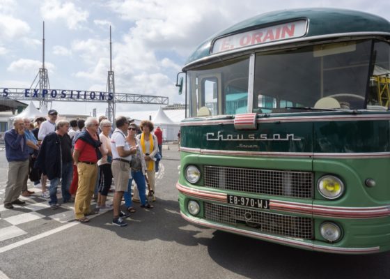 Groupe de visiteurs lors des Journées du patrimoine s'apprêtant à monter dans un bus des années 1950.