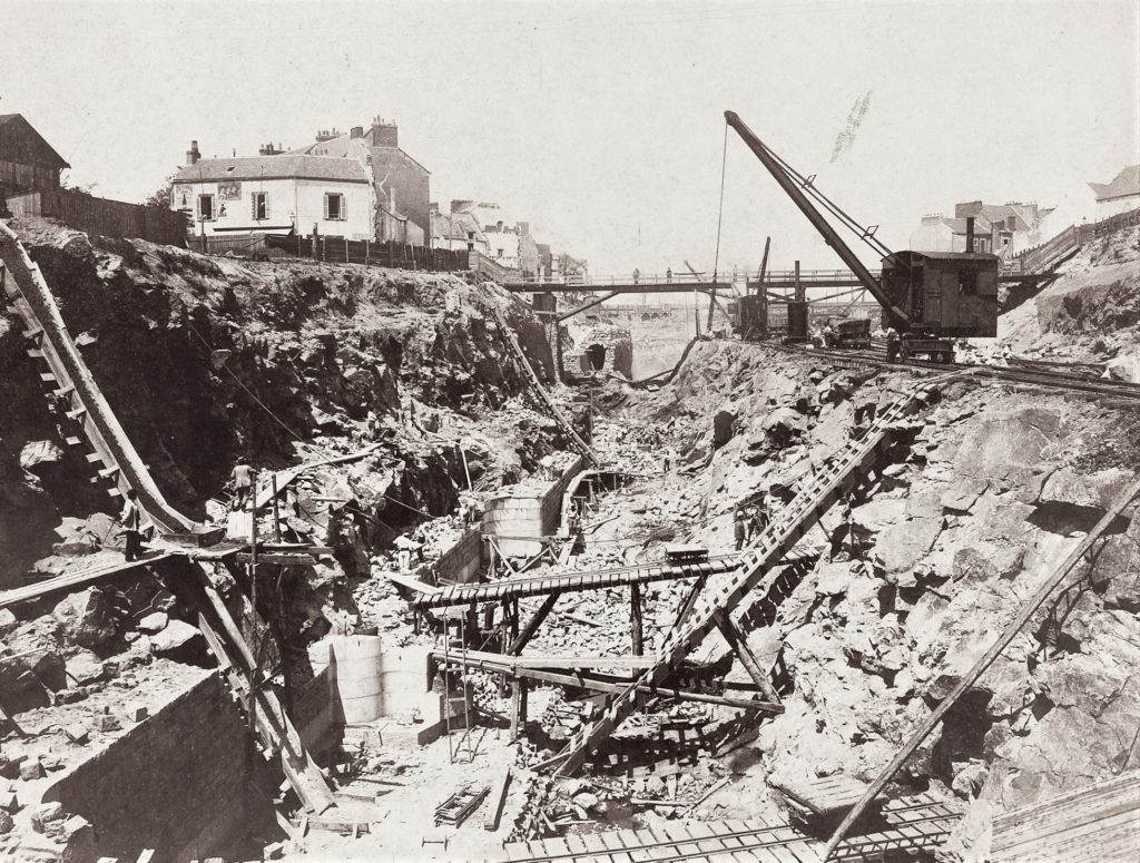 Photographie des travaux de l'entrée sud où l'on peut voir une immense tranchée séparant la ville en deux.